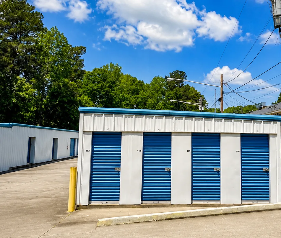 Bank of drive-up storage units with blue roll-up doors at Savy Space Self Storage
