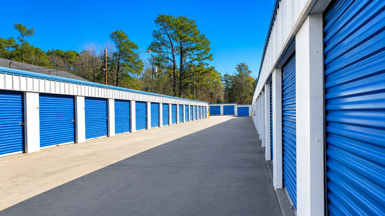 Wide drive-up aisle of blue storage unit doors at Savy Space Self Storage in Augusta, GA