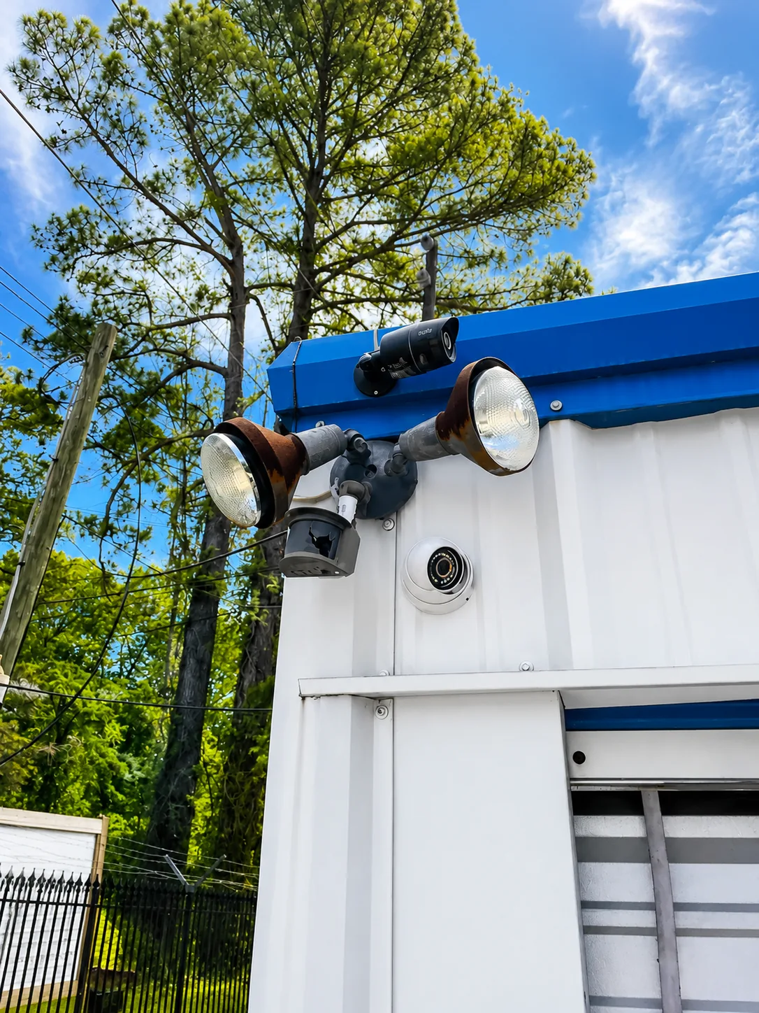 Security cameras and floodlights mounted on a building at Savy Space Self Storage